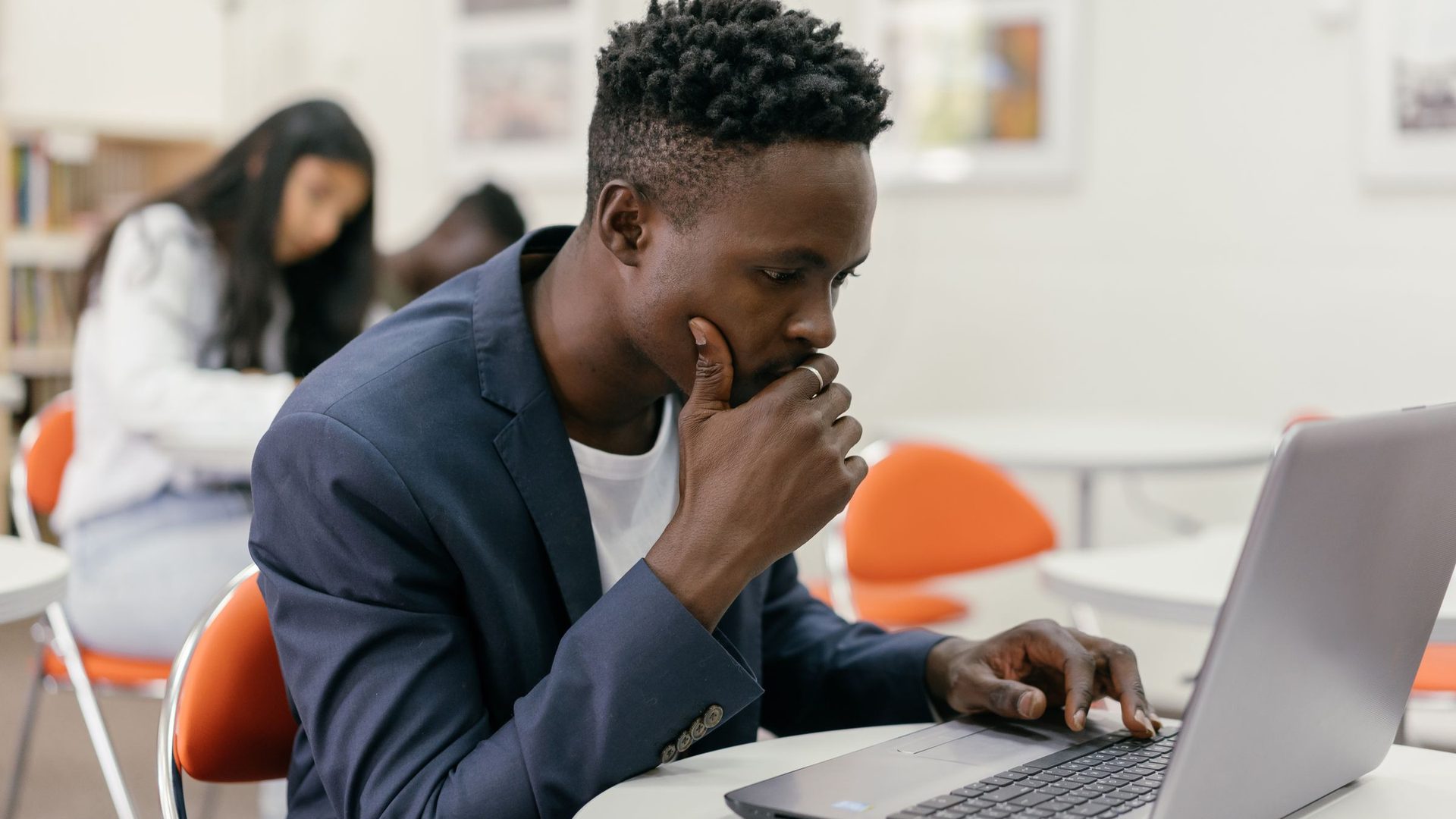 Jovem concentrado ao portátil numa sala de estudo, a preencher o pré-registo online da UEM