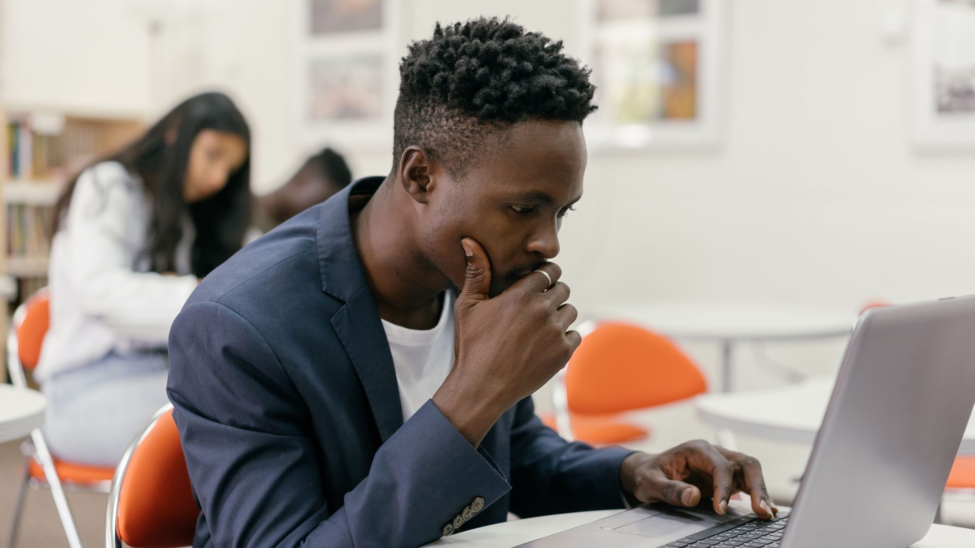 Estudante concentrado a analisar dados no computador numa sala de estudo